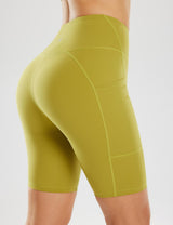 Women's 8" light compression yoga shorts in olive green with pockets and high waist.