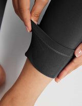 Close-up of black thermal leggings showing soft fleece lining and durable stitching.