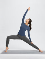 Woman in navy long-sleeve top and gray leggings doing Warrior II yoga pose