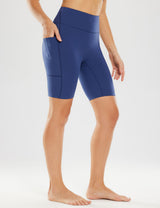 Woman in navy blue 8" light compression yoga shorts with pockets, showing side view and thigh detail.