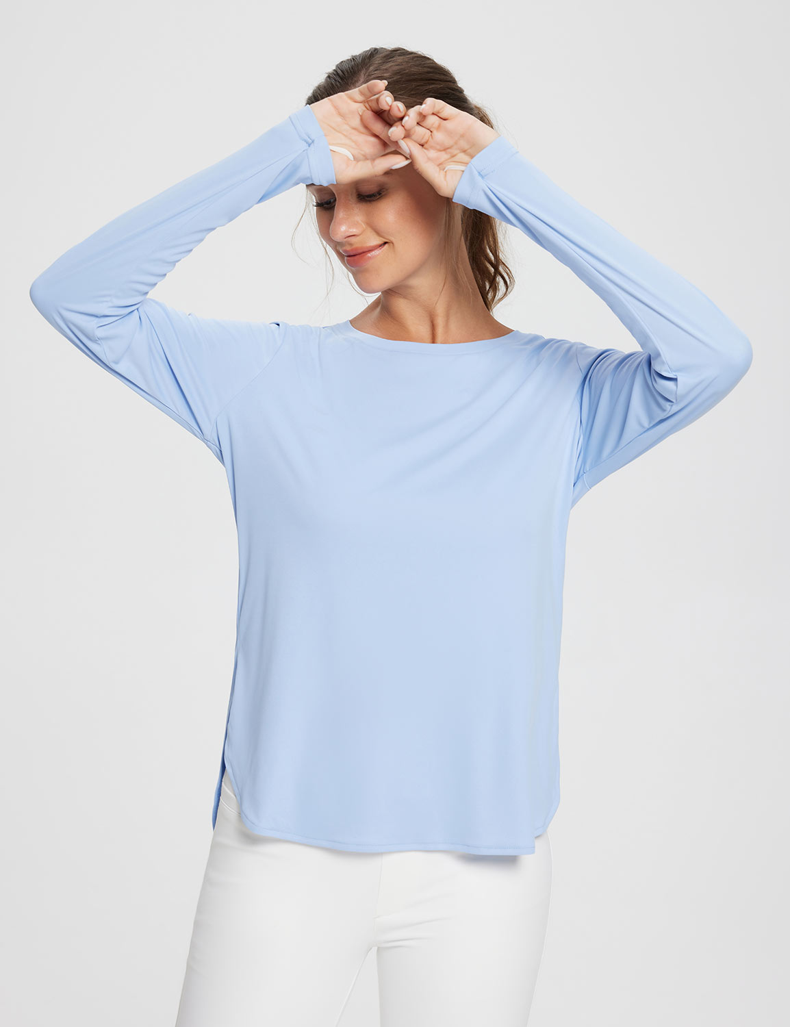 Light blue UPF 50+ long sleeve shirt with crew neck and thumbholes on a woman wearing white pants. #color_Kentucky Blue