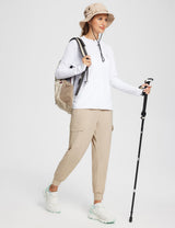 Woman in white UPF 50+ zip-up jacket, khaki cargo pants, sun hat, and backpack, holding a hiking pole. #Baleaf Hoodie