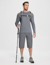 Man wearing grey long-sleeve sun shirt, cargo shorts, and hiking shoes, holding a trekking pole and wearing a backpack.