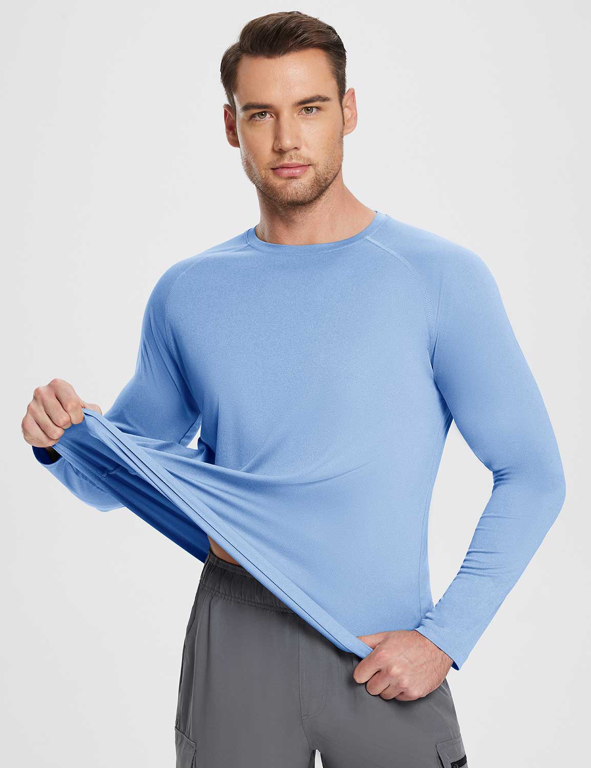 Flyleaf Men's UPF 50+ crew neck long-sleeve sun shirt in light blue, showing fabric stretch.