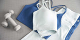 Blue and white activewear set with dumbbells on yoga mat