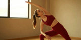 Woman in red yoga pants practicing yoga in a cozy gym, Valentine's day activewear, yoga mat
