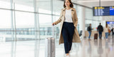 Stylish petite woman wearing fitted petite travel pants walking in airport terminal