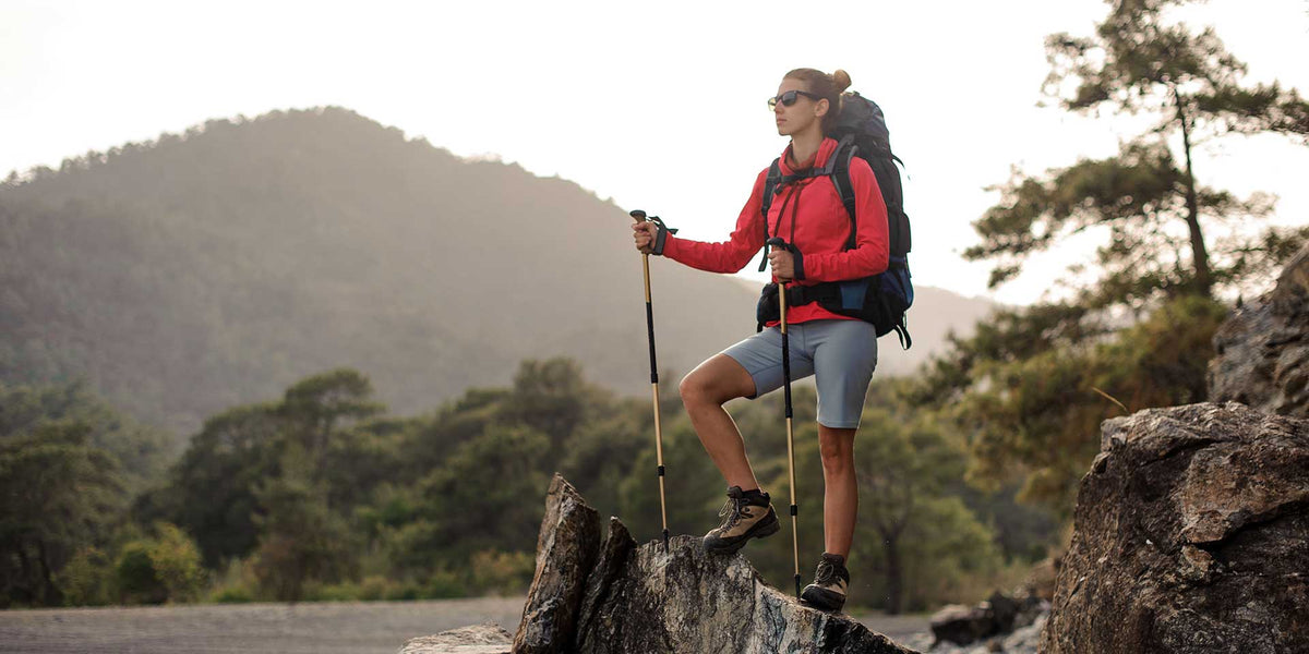woman hiking in womens knee length cargo shorts with backpack and trekking poles