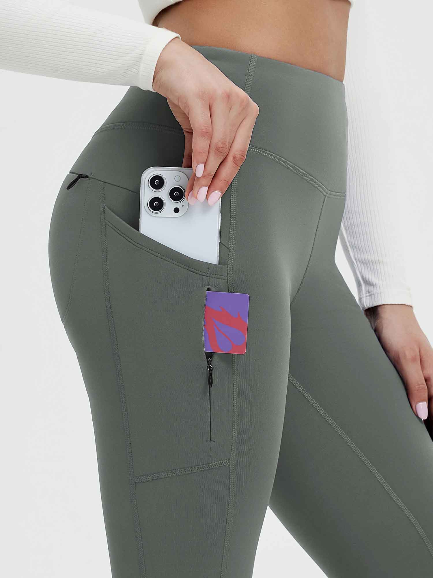 Olive green 25" fleece-lined yoga leggings showing phone in side pocket & zippered pocket. #color_Dark Gray