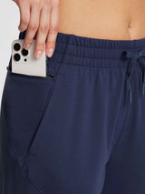 Women's navy fleece jogger pants with drawstring and phone in zippered pocket. #color_Navy Blue