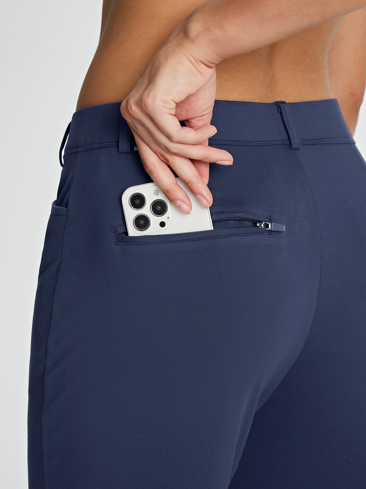 Navy fleece-lined golf pants with zippered phone pocket detail.