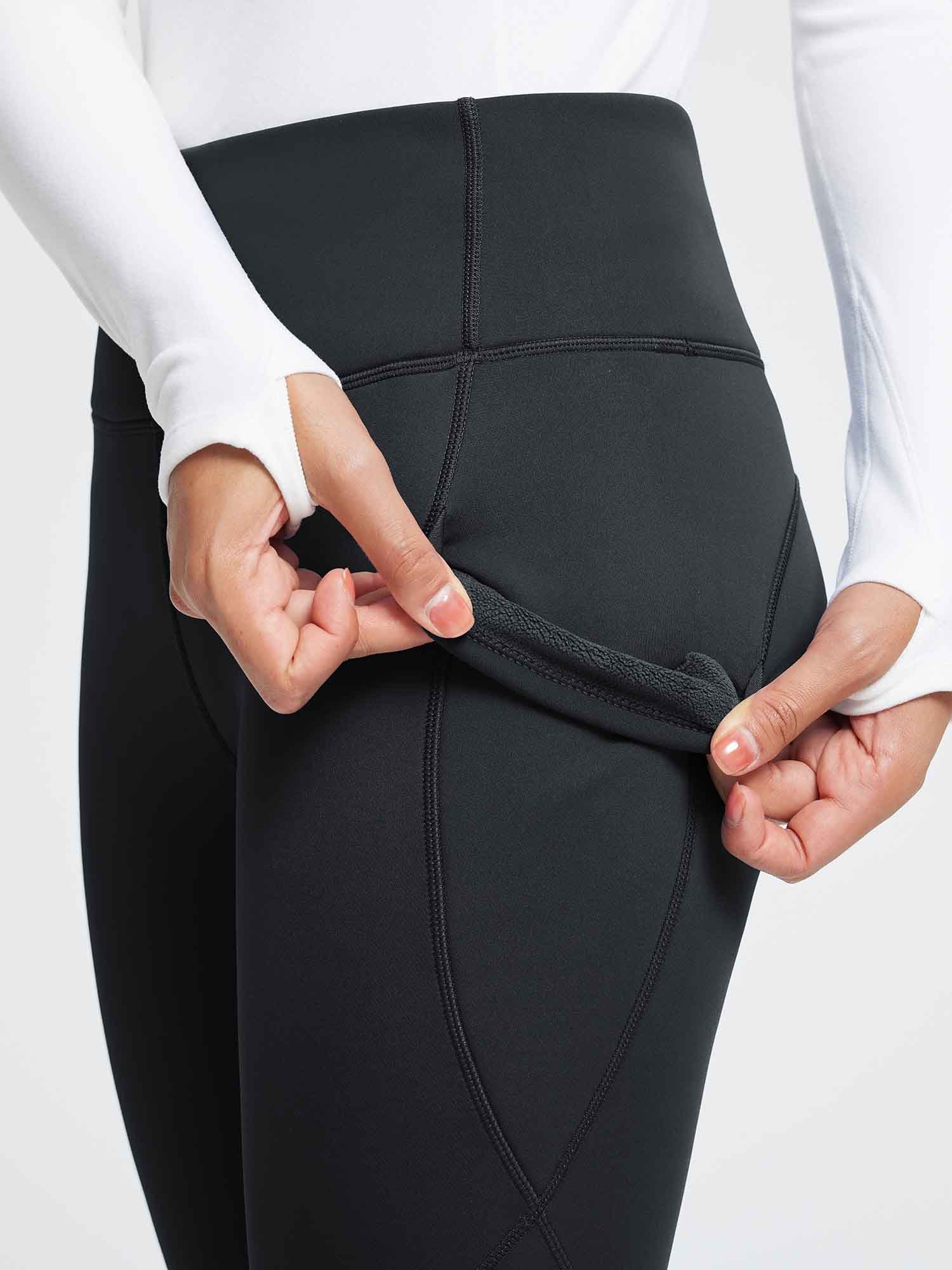 Close-up of black high-waist thermal fleece yoga leggings, revealing soft lining.