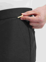 Close-up of hand placing golf tee into pocket of Baleaf dark grey UPF 50+ golf pants. #color_Black