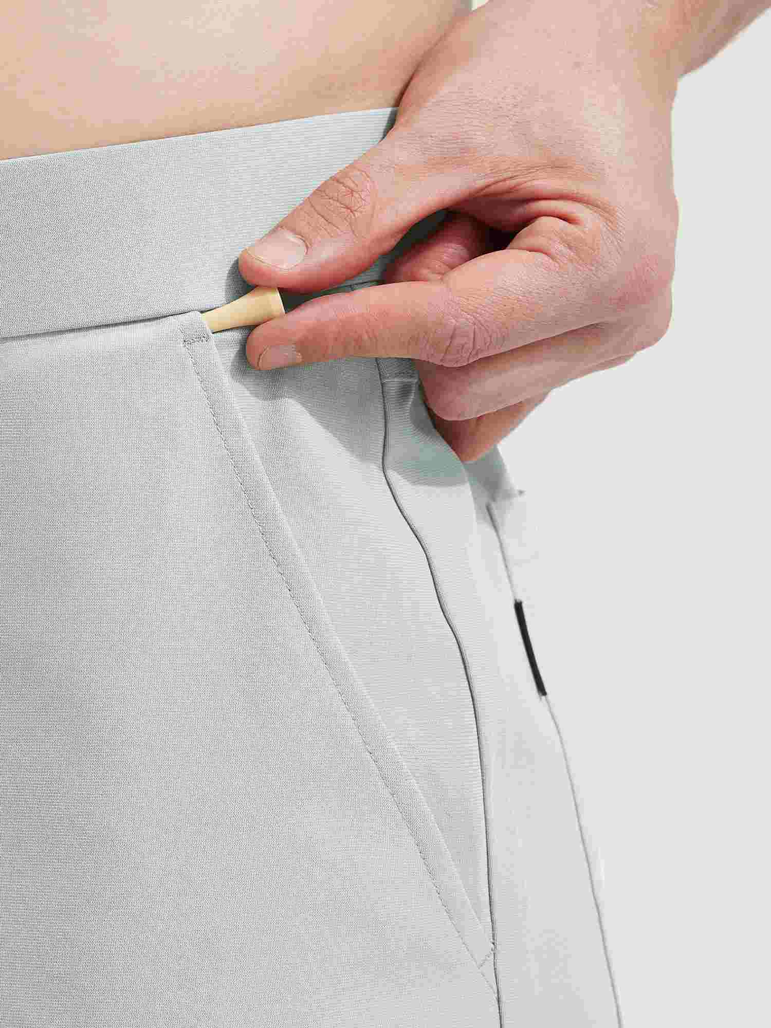 Baleaf 30'' UPF 50+ golf pants: hand tucking golf tee into pocket. #color_Light Gray