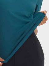 Teal Baleaf UPF 50+ shirt: Hand stretches fabric showing ultra-soft, breathable, moisture-wicking feel.