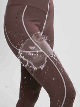 Brown fleece cycling leggings showing water-resistant treatment with splashing water, side zippered pocket.