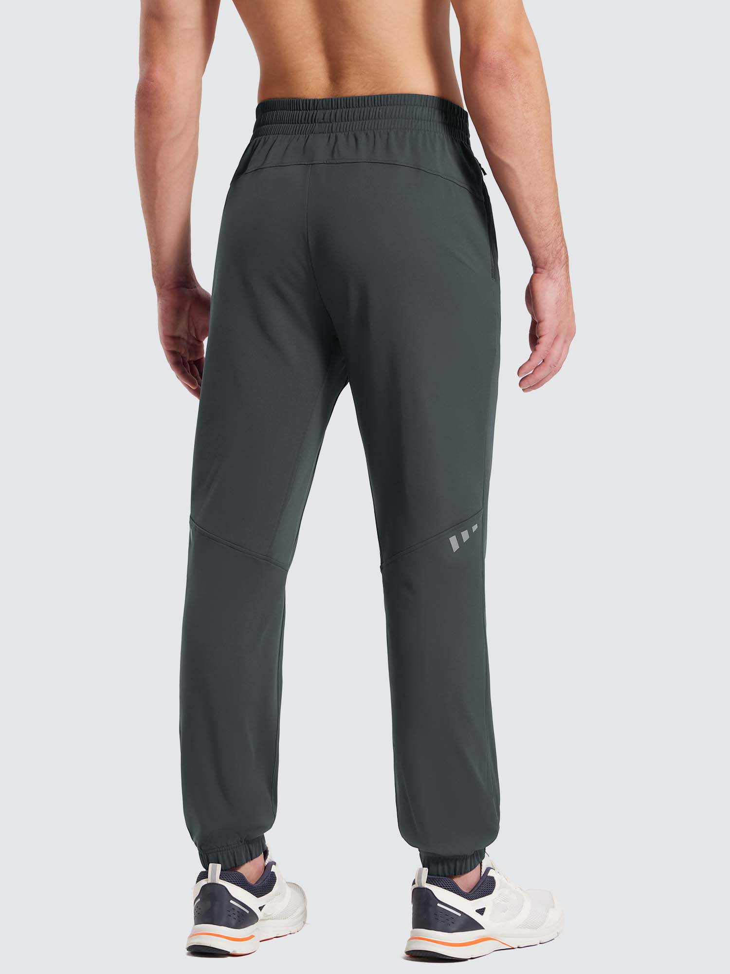 Back view of men's dark grey fleece jogger pants with reflective side accents and cuffed ankles. #color_Dark Gray