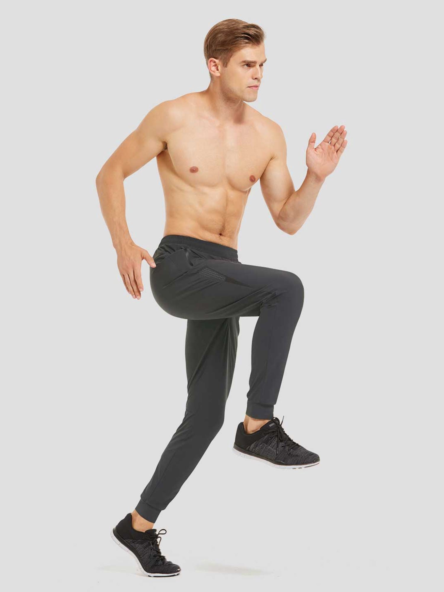 Men's charcoal lightweight jogger running pants with zippered pockets, on a runner. #color_Dark Gray