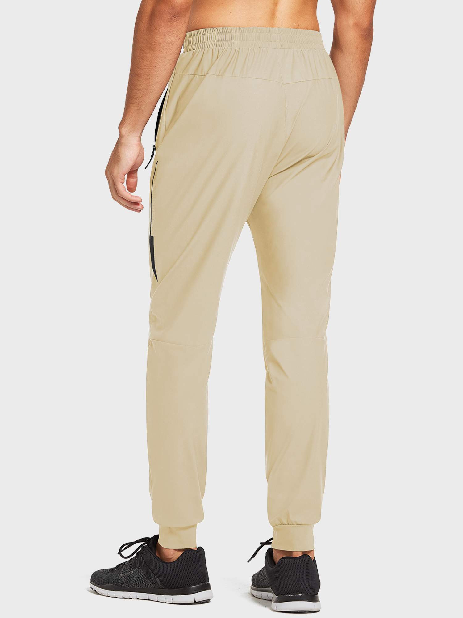Lightweight beige men's jogger running pants with zippered pockets and elastic tapered cuffs. #color_Light Brown