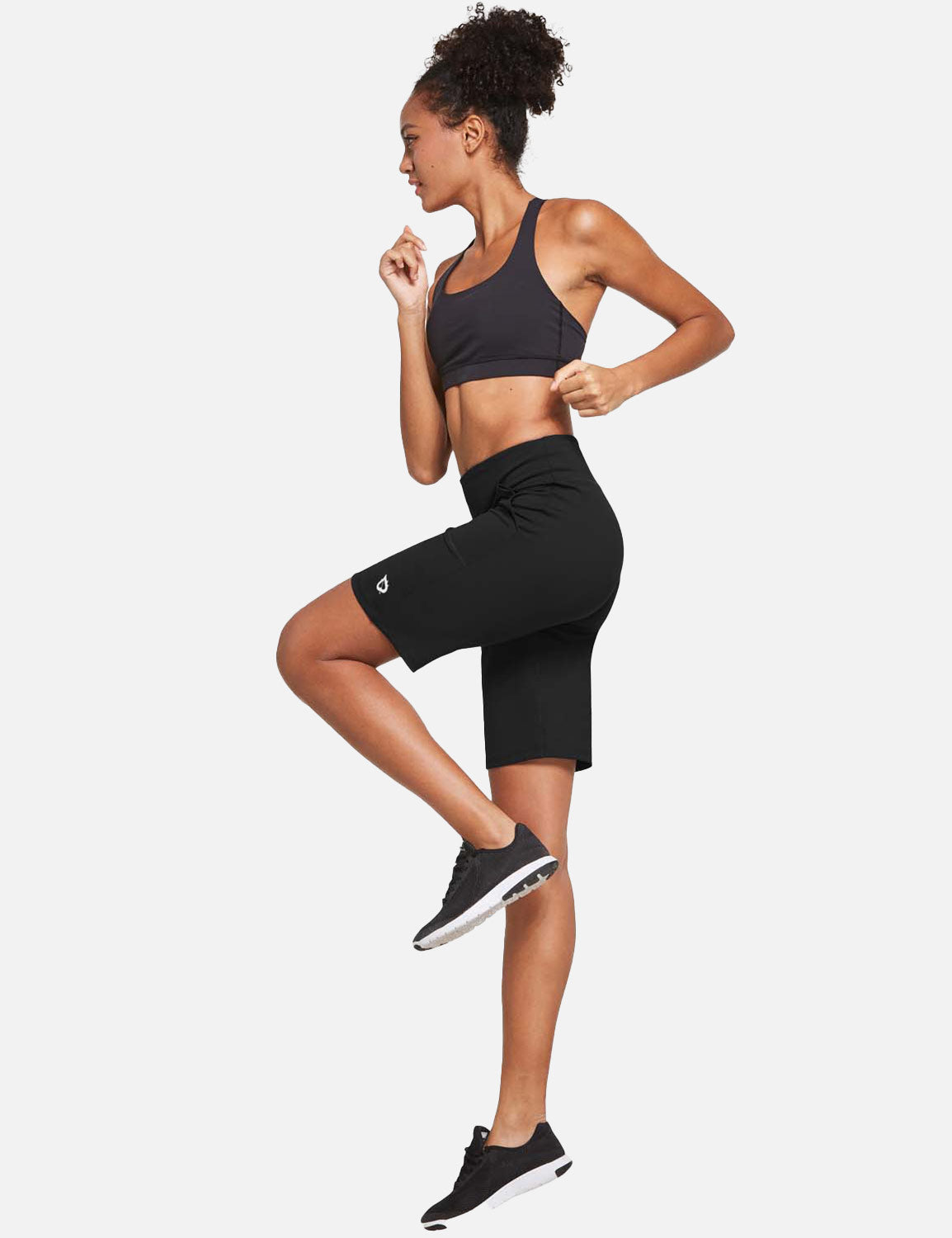 Woman running in black Laureate High Rise Bermuda Shorts and sports bra. #color_Black
