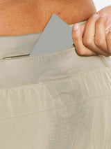 Women's 7" running shorts in tan, hand tucks card into secure hidden zipper pocket. #color_Khaki