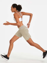 Woman running in khaki 7" women's athletic shorts featuring A-line fit and wide high-rise waistband. #color_Khaki