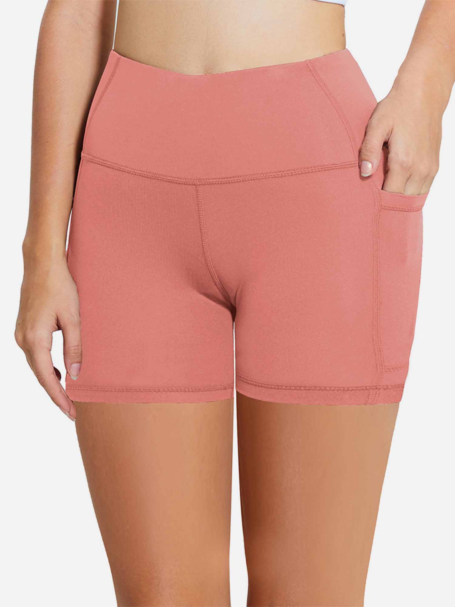 Coral pink women's 5-inch high-waisted compression biker shorts featuring side pockets.
