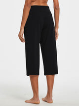 Woman from the back wearing black wide-leg cotton capri pants with a white background. #color_Black