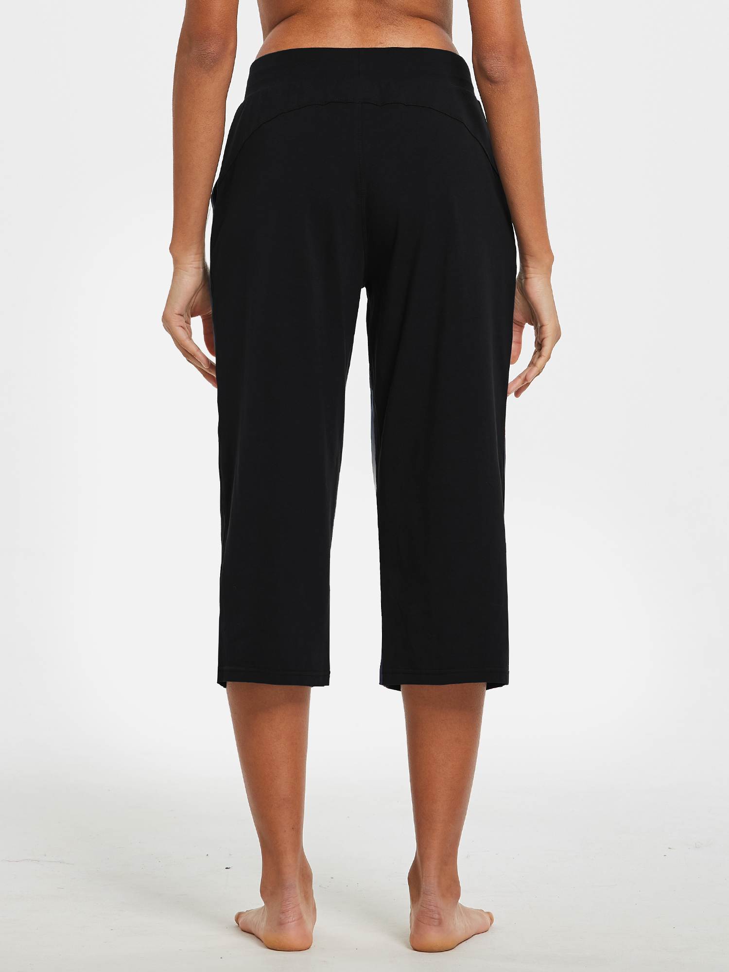 Woman's back view of black wide-leg cotton capri pants with pockets. #color_Black