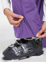 Outdoor ski bib pants in purple, showing zipper detail with ski boot #color_Purple