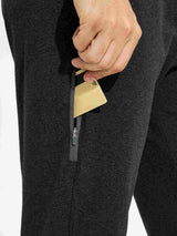 Man's dark gray cotton yoga cargo pants with a zippered side pocket holding a card. #color_Dark Gray