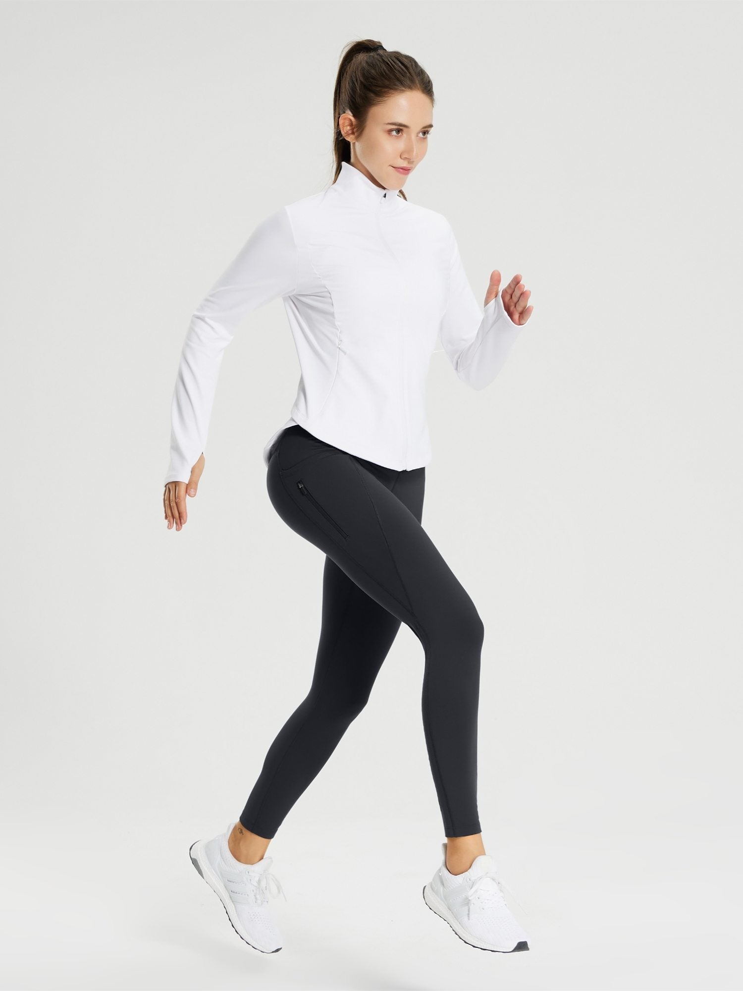 Women's black fleece-lined cycling leggings with zippered pocket and white athletic jacket. #color_Black