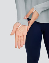 Light gray crew neck long sleeve t-shirt with thumbholes, worn with navy blue leggings.