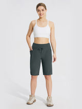 Woman wearing dark gray 11" quick-dry hiking cargo shorts with a white sports bra and hiking boots. #color_Dark Gray