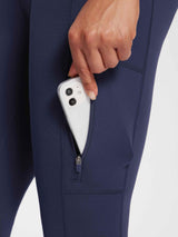 Women's navy knit fleece leggings with phone in zippered pocket.