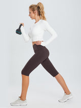 Plus size women's dark brown knee-length capris with pockets during a kettlebell workout. #color_Dark Brown