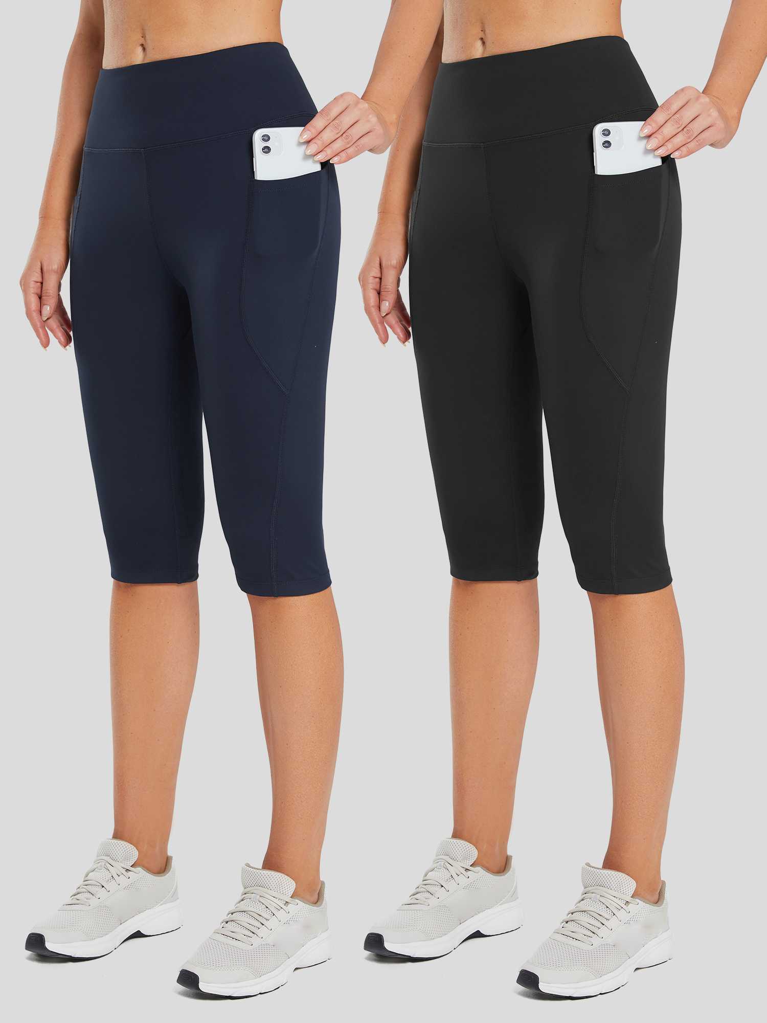 Women's stretchy high-waisted capris, navy & black, deep pockets holding phones. #color_Black/Blue