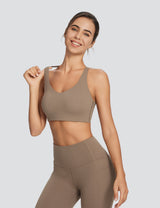 All-day active essentials: Woman in taupe spaghetti strap low impact sports bra & leggings. #color_Brown
