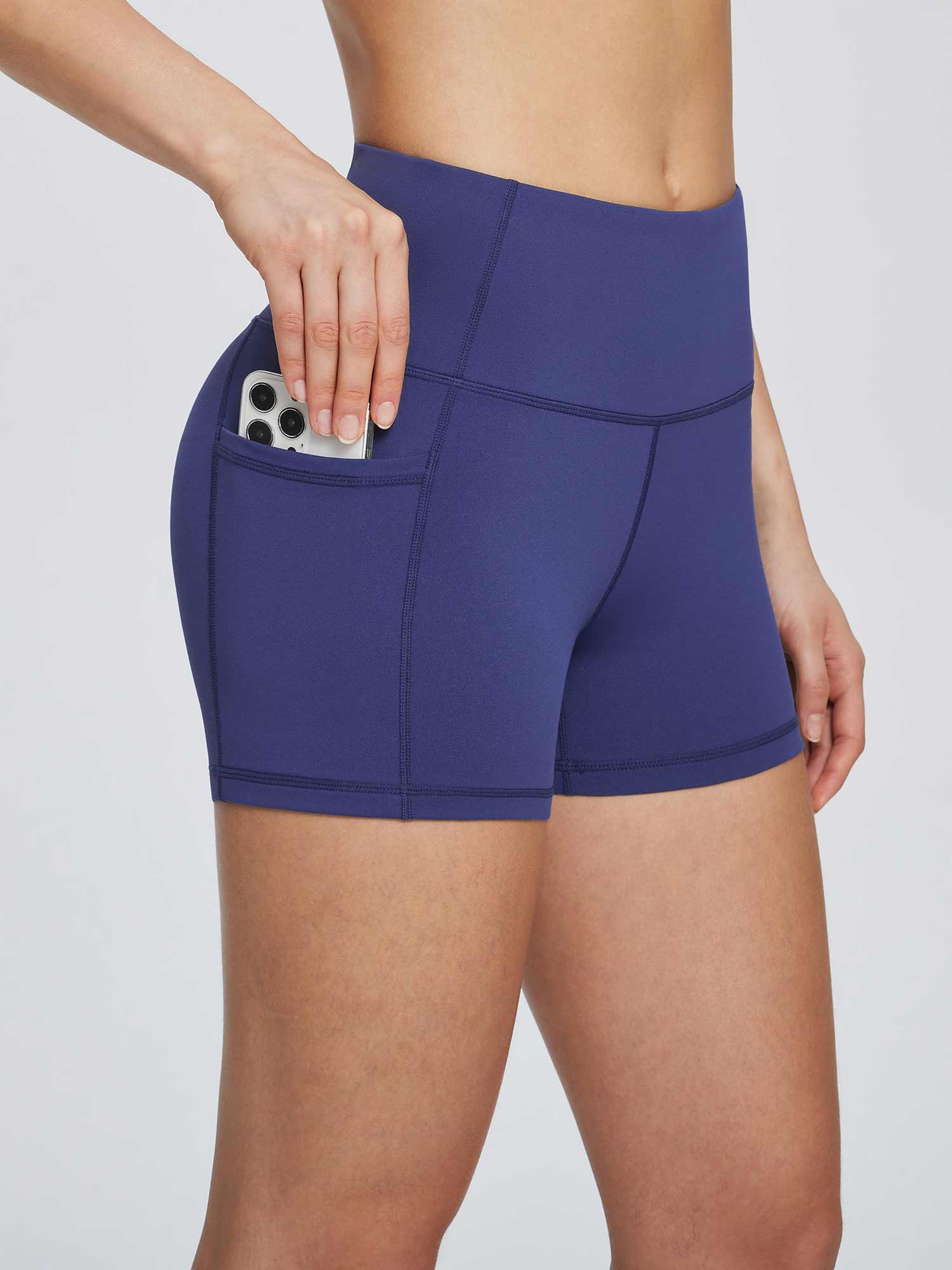 Navy blue women's 3" high-waisted compression biker shorts with side pocket holding a smartphone. #color_Navy Blue