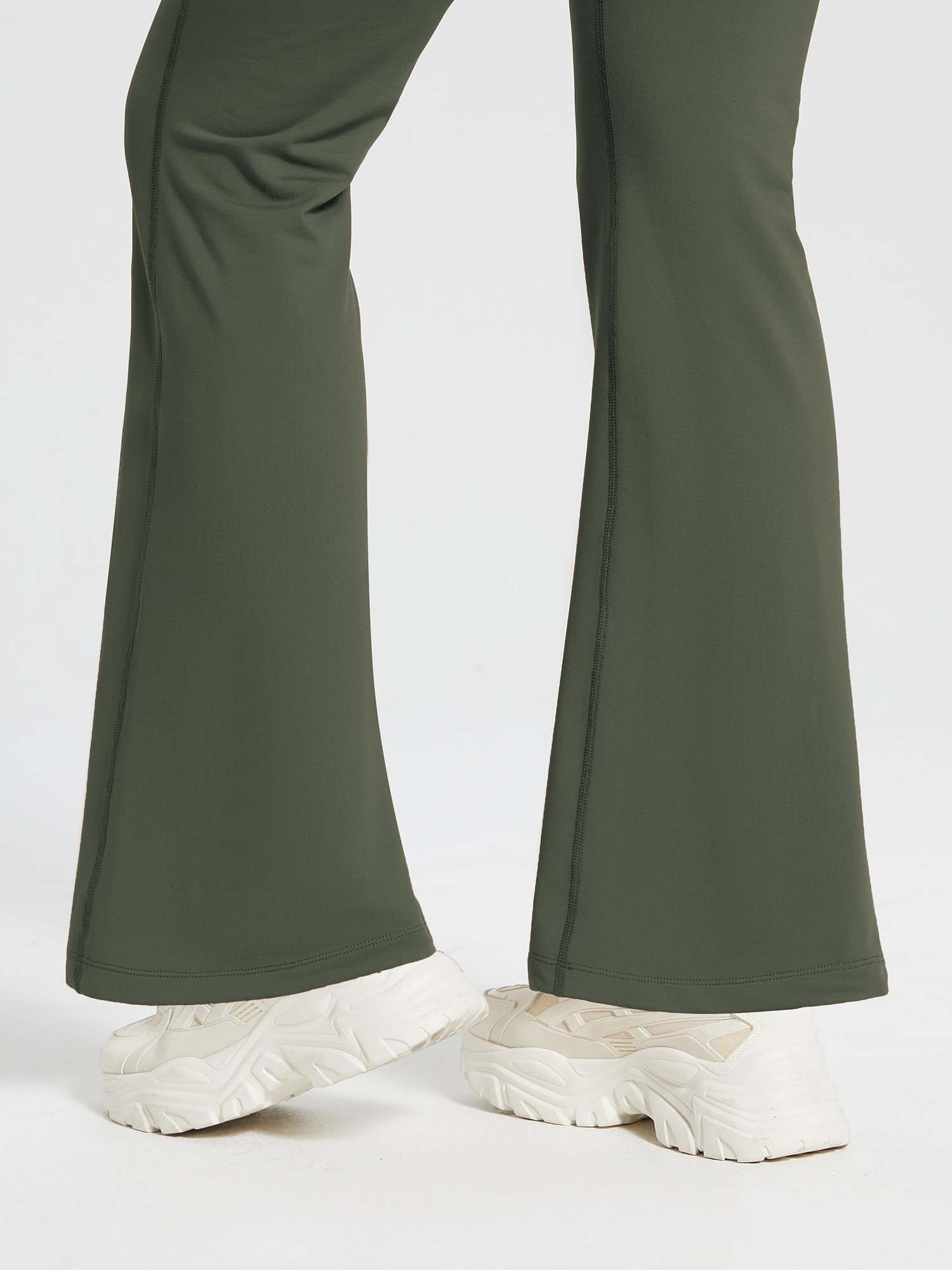 High-waist fleece-lined olive green flare pants with drawstring, bootcut hem, and sneakers. #color_Army Green