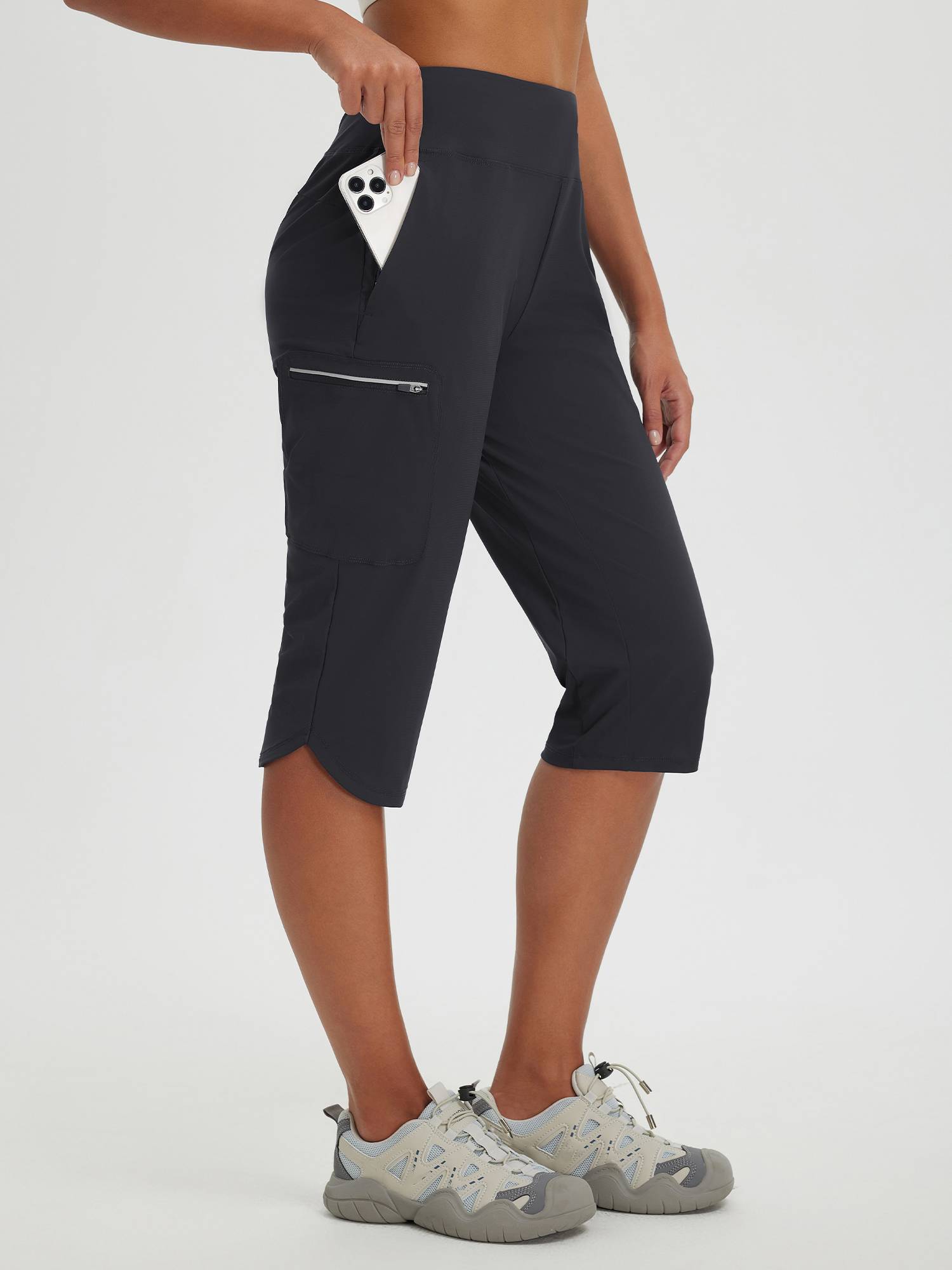 Women's dark grey capris with zippered pockets, ideal for cycling and hiking. #color_Black