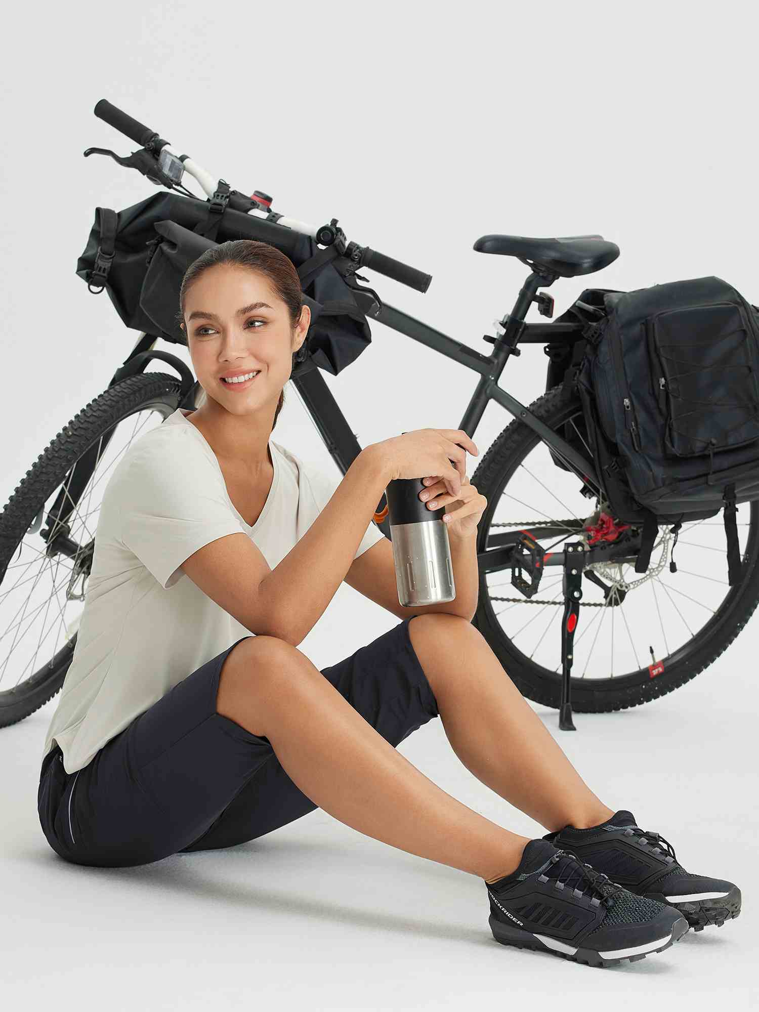 Women in navy women's 17 inch capris for cycling and hiking, by bike. #color_Black