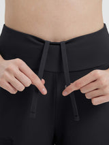 Hands adjusting black drawstring on women's 14" cycling capris #color_Black