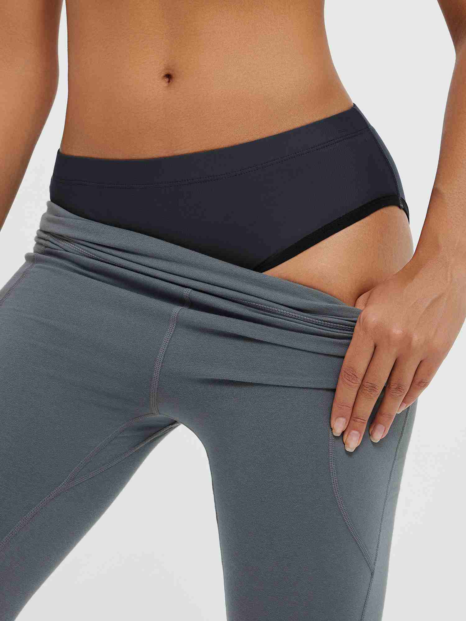 Women's padded cycling underwear in dark grey, shown under grey cycling shorts. #color_Black