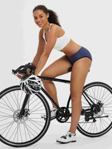Women's 4D padded bike underwear featured on a woman cycling. #color_Navy Blue