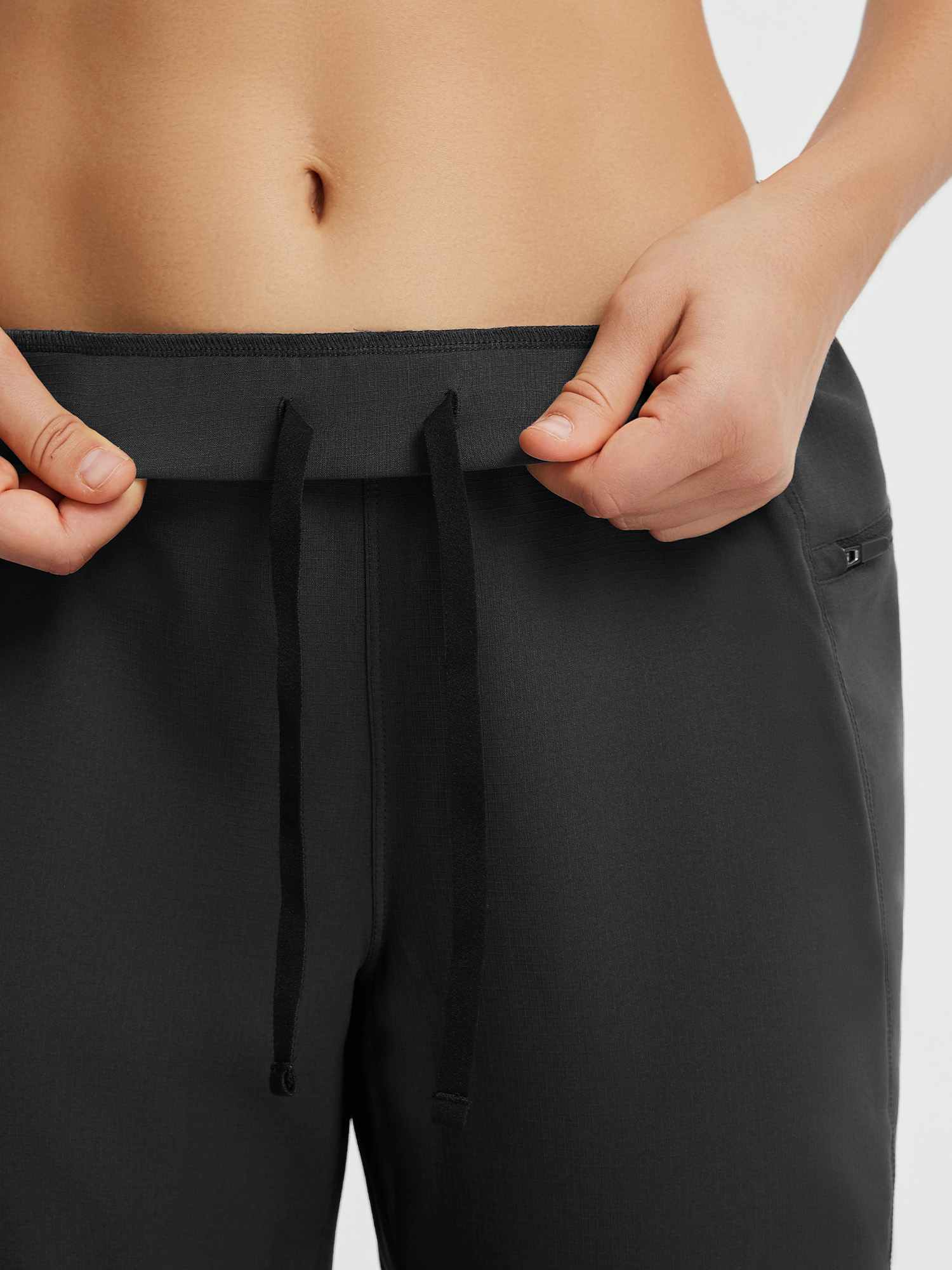 Black tapered cycling pants: elastic waistband, adjustable drawstring, side zip pocket. #color_Black