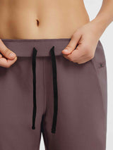 Elastic tapered cycling pants with black drawstring and zippered side pocket. #color_Dark Brown