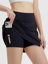 Women's black high-waisted golf skort featuring side pocket with phone and golf tee loops. #color_Black