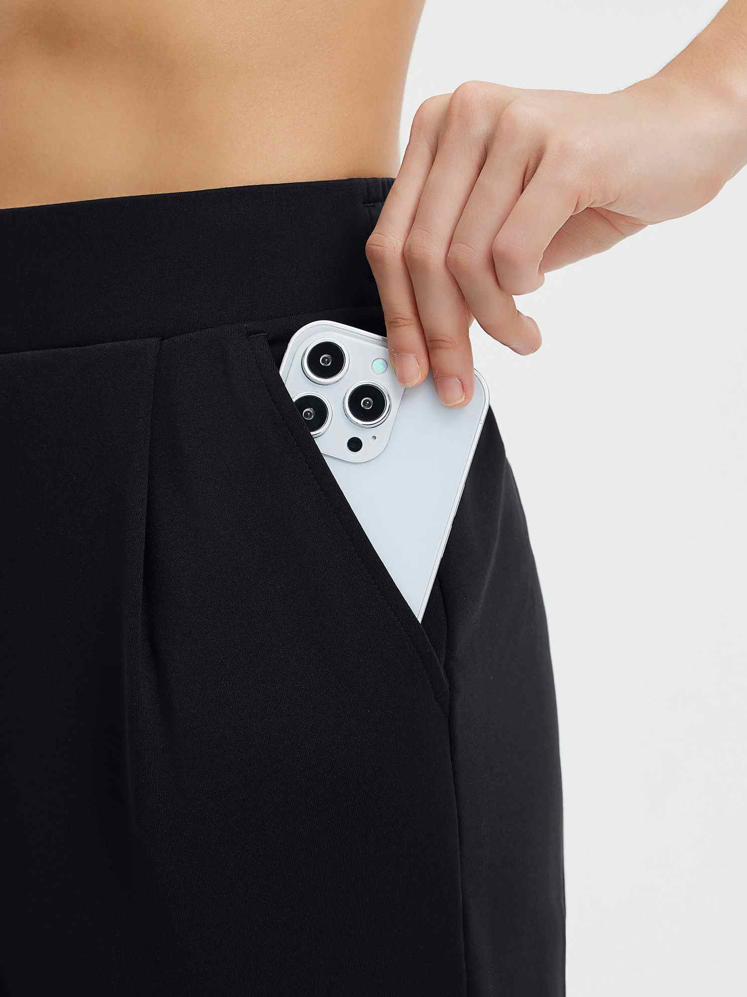 Black slim-fit golf pleated pants with functional smartphone pocket. #color_Black