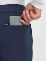 Men's navy fleece golf pants with zippered utility pocket holding wallet. #color_Navy Blue